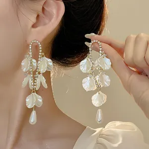 Elegant French retro shell petal drop earrings with teardrop pearls shown on model