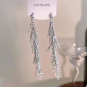 Détail macro de boucles d'oreilles pendantes élégantes à franges argentées pour femme