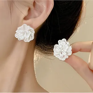 Close-up of elegant French vintage white 3D flower earrings featuring realistic textured petals