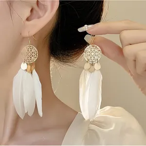 Close-up of elegant French vintage tassel earrings with white feathers on a model.
