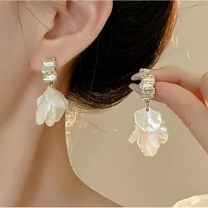 Macro detail shot of French retro shell petal earrings with sparkling crystal studs