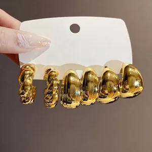 Elegantes Set aus goldenen geometrischen Tropfenohrringen auf einer weißen Displaykarte