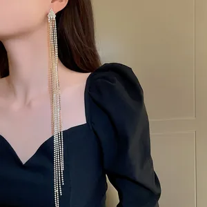 Detail shot of elegant silver long tassel rhinestone earrings on a female model