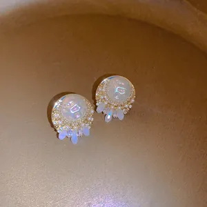 Macro detail of elegant French vintage earrings with iridescent shells and pearl fringe.
