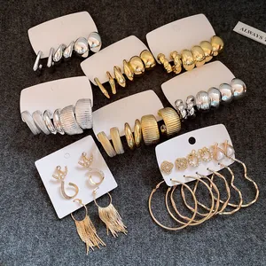 Detailansicht unregelmäßiger geometrischer Ohrring-Sets in Gold und Silber auf weißen Karten.