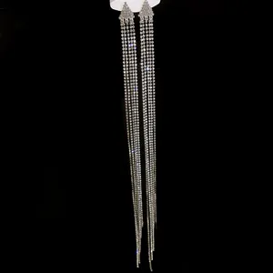 Close-up detail of sparkling long tassel rhinestone earrings against a dark background