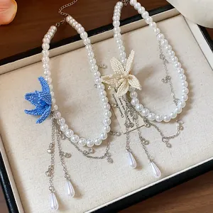 Detailed view of handmade beaded flower and teardrop pearl charms on necklaces