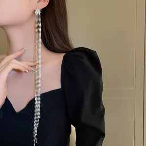 Close-up detail of luxury silver needle long rhinestone tassel earrings for women