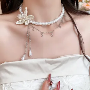 Detailed macro shot of elegant white beaded flower with dangling waterdrop pearl charms