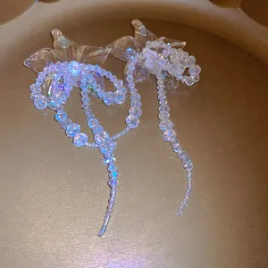 Macro detail of French retro shell earrings featuring iridescent beaded tassel drops