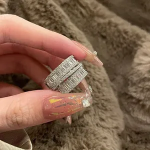 Detailed macro view of a sparkling multi-layer zircon geometric ring held by hand
