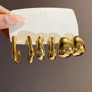 Detailansicht unregelmäßiger geometrischer goldener Wassertropfen-Ohrringe auf Karte