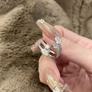Elegant multi-layer open ring with sparkling geometric zircons on a manicured hand.