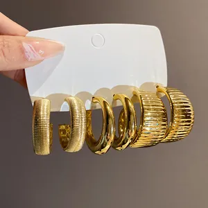 Detaillierte Nahaufnahme von drei Paar goldenen Vintage-Creolen auf einer Displaykarte.