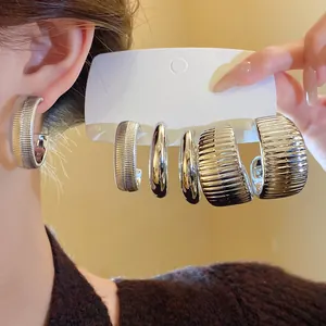 Detailansicht eines Sets unregelmäßiger silberner Ohrringe mit gerippter und glatter Optik