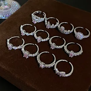 Detailed display of multiple silver-colored cubic zirconia rings with pink stones.