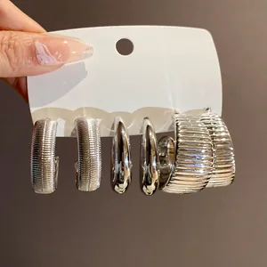 Detailansicht eines 3-teiligen silbernen geometrischen Ohrring-Sets mit strukturierten Oberflächen