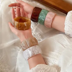 Detail view of marbled acrylic rectangular elastic bracelets in various vintage colors