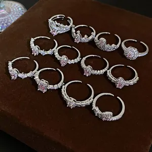 Close-up of elegant adjustable silver rings featuring pink zircon and pave stones