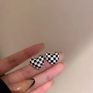 Gros plan de boucles d'oreilles en forme de cœur avec un motif en damier noir et blanc