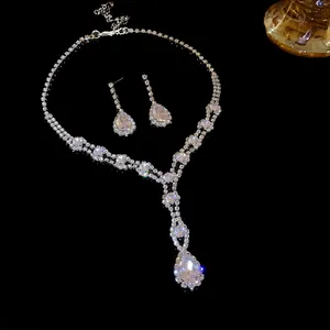 Détail d'un élégant ensemble collier et boucles d'oreilles en strass goutte d'eau sur fond noir