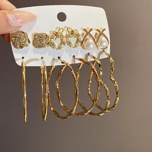 Detail eines vergoldeten Ohrring-Sets mit Perlen und großen herzförmigen Creolen