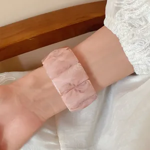 Close-up of a pink marbled acrylic rectangular block elastic bracelet worn on the arm