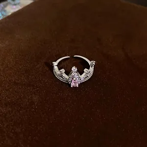 Close-up detail of silver crown ring featuring a teardrop pink zircon and pavé stones.