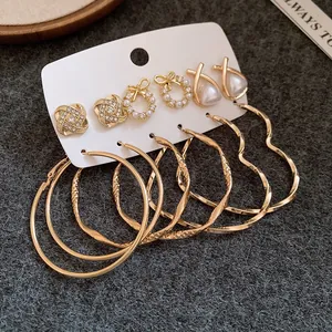 Vielseitiges Set mit sechs Paar goldfarbenen Ohrringen mit Kunstperlen und großen Creolen.