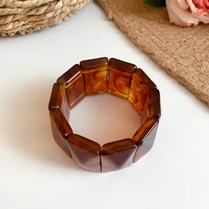 Detail of vintage amber swirled acrylic elastic bracelet with rectangular segments.