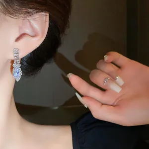 Gros plan de boucles d'oreilles en strass taille marquise sur l'oreille