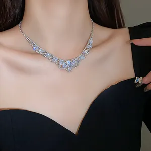 Collier élégant en cristal argenté porté par un mannequin en robe noire chic.