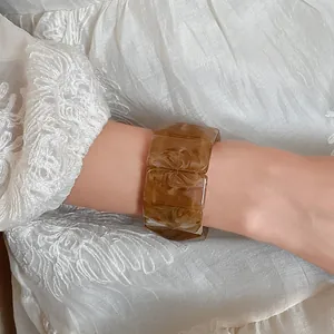 Detailed macro view of a vintage rectangular marbled acrylic elastic bracelet on a wrist