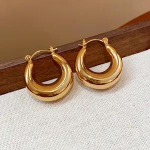 Hochwertige Detailaufnahme der 18K echtgoldplattierten klobigen Creolen mit Spiegelfläche.