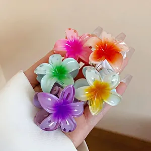 Assortiment de mini pinces à cheveux fleurs colorées tenues en main pour la taille