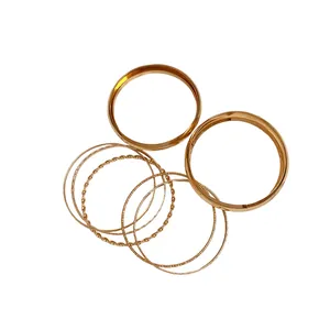 Set of six gold-tone geometric textured metal bangles featuring twisted and smooth designs