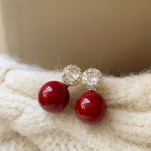 Boucles d'oreilles perles rouges rétro avec fleurs en zircon sur un tissu tricoté doux