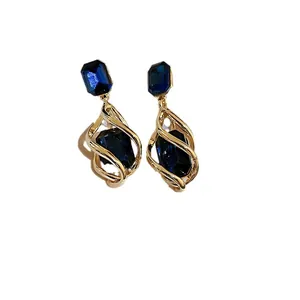 Elegant gold drop earrings featuring deep blue gemstones and a spiral cage design