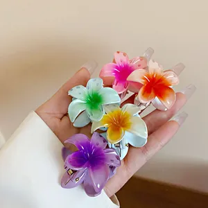 Détail de plusieurs mini pinces à cheveux colorées en forme de fleur de frangipanier.