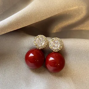 Gros plan détaillé de boucles d'oreilles pendantes rouges avec clous en zircon sur soie