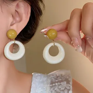 Orecchini pendenti tondi in acrilico senape e crema con perno in argento S925