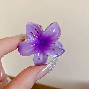 Gros plan d'une pince à cheveux fleur violette translucide avec un effet dégradé