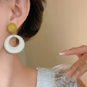 Eleganti orecchini pendenti in acrilico con perno oliva e ciondolo circolare bianco