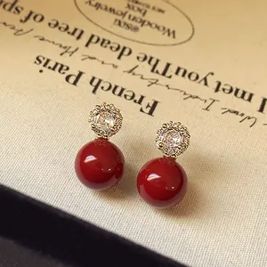 Gros plan sur boucles d'oreilles perles rouges avec clous en fleurs de zircon