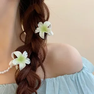 Gros plan de pinces à cheveux en forme de lys blancs sur une tresse de cheveux châtains