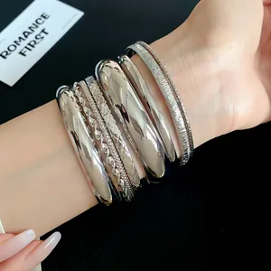 Close-up of stylish silver geometric textured metal bangles on a wrist