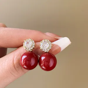 Vue détaillée des boucles d'oreilles pendantes rouges vintage avec zircons étincelants