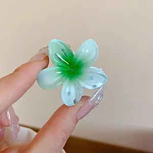 Vue détaillée d'une petite pince à cheveux en forme de fleur avec dégradé vert menthe