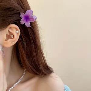 Vue détaillée d'une mini pince à cheveux en forme de fleur violette sur cheveux bruns