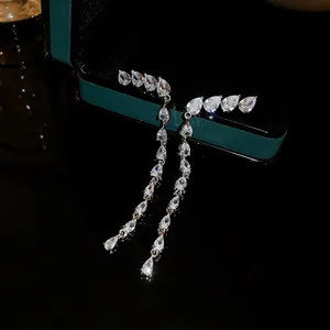 Exquisite macro view of long tassel earrings with sparkling pear-shaped cubic zirconia.